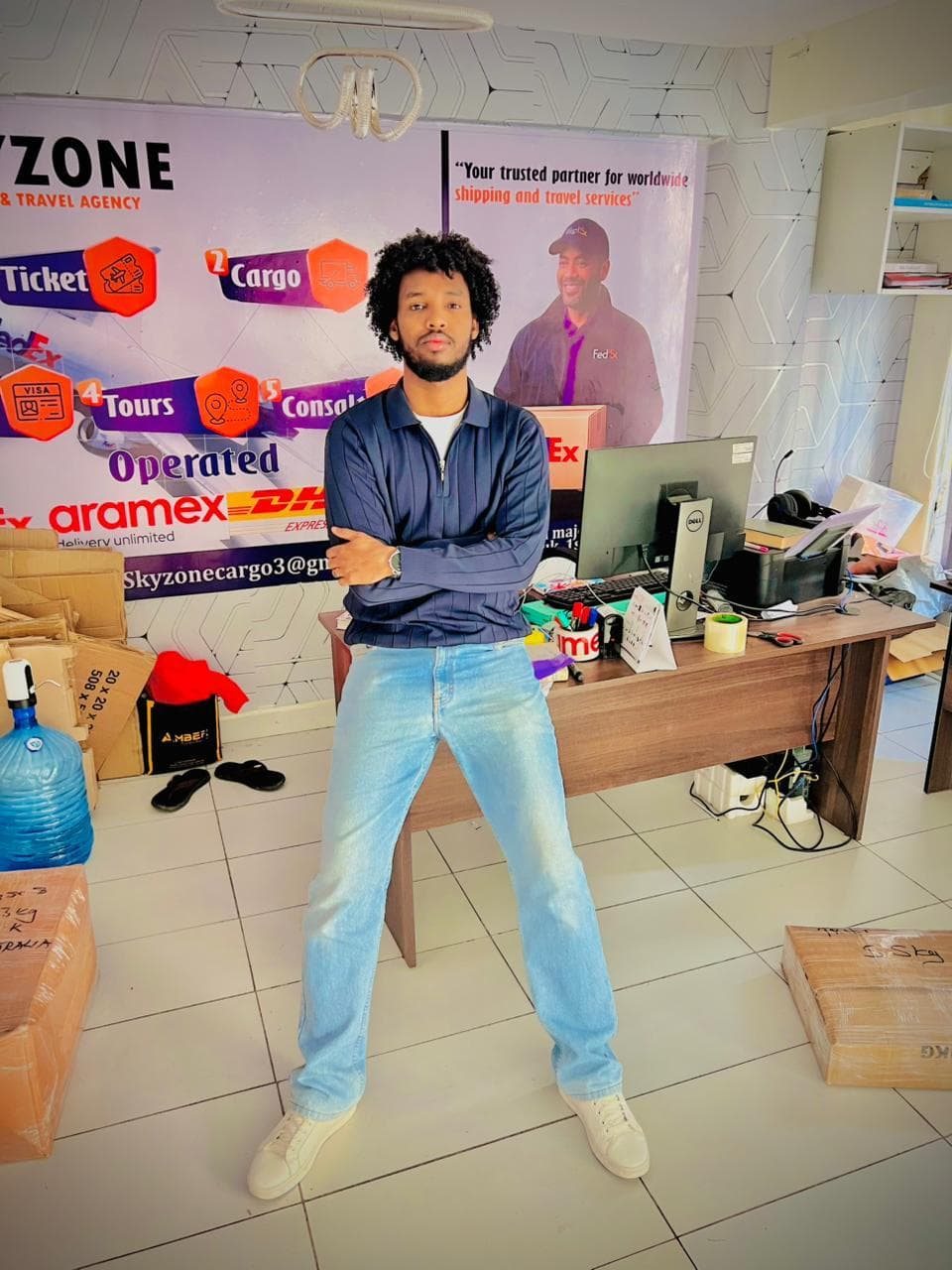 At the Skyzone service desk in front of the branded services wall, with shipments packed for dispatch